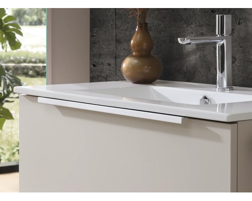 Moderne wastafelonderkast met witte wastafel en verchroomde mengkraan voor een gestructureerde wand.