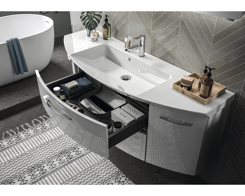 Moderne badkamer met wit wastafelmeubel, open lade, geïntegreerde wastafel en vrijstaand bad.