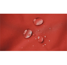 Waterdruppels parelen op een waterafstotend textieloppervlak, detailopname van de weefselstructuur.