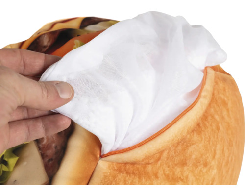 Een hand houdt de witte binnenvoering vast uit de ritssluiting van een pluche hamburger.