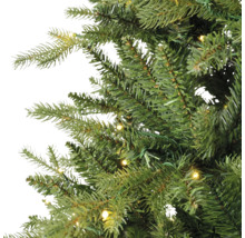 Detailopname van de takken van een kunstkerstboom met geïntegreerde warmwitte LED-verlichting.