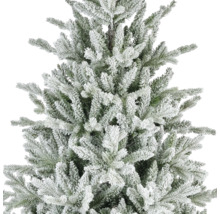 Dichtbijopname van een kunstkerstboom met besneeuwde takken en groene naalden.