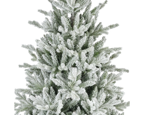 Dichtbijopname van een kunstkerstboom met besneeuwde takken en groene naalden.