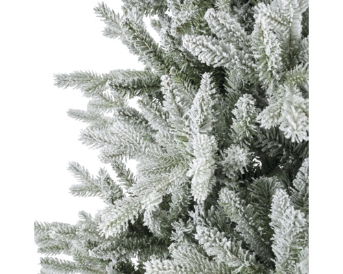 Detailweergave van de besneeuwde takken van een kunstkerstboom voor kerstdecoratie.