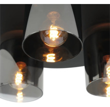 Moderne plafondlamp met cilindrische kappen van rookglas en brandende filamentlampen.