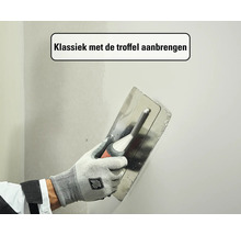 Klassiek aanbrengen van plamuur op een muur met een troffel.
