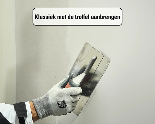 Klassiek aanbrengen van plamuur op een muur met een troffel.