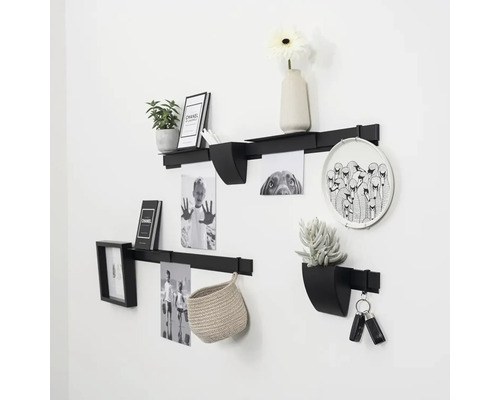 Modulair wandplanksysteem van metaal met planken, houders en decoratie-elementen voor flexibele wandinrichting en opslag.