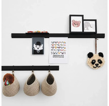 Twee zwarte wandplanken voor het opbergen van kinderkamerdecoratie, afbeeldingen en speelgoed, gecombineerd met hangende gevlochten manden.