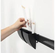 Hand plaatst een pen in een opbergbakje dat aan een wandrail is bevestigd voor het organiseren van kantoorbenodigdheden of gereedschap.
