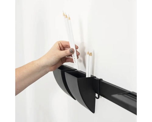 Hand plaatst een pen in een opbergbakje dat aan een wandrail is bevestigd voor het organiseren van kantoorbenodigdheden of gereedschap.