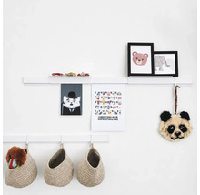 Witte wandplanken met decoratieve elementen zoals fotolijsten, speelgoedauto, alfabetposter en hangende gevlochten opbergmanden.