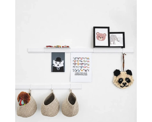 Witte wandplanken met decoratieve elementen zoals fotolijsten, speelgoedauto, alfabetposter en hangende gevlochten opbergmanden.