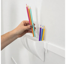 Een hand plaatst kleurpotloden in een witte wandorganizer voor het opbergen van schrijfgerei.