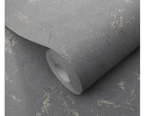 Een rol vliesbehang met gestructureerd oppervlak en metalen accenten voor een moderne wandafwerking.