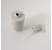 Beige zeepdispenser van keramiek, gedemonteerd in flacon en pompkop met stijgbuis.