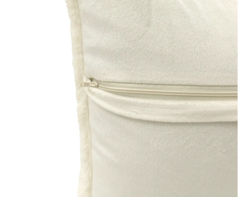 Detailopname van een sierkussen met ritssluiting en zachte pluche stof.