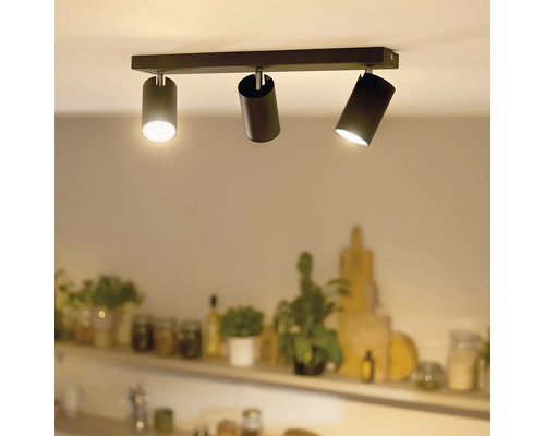 Moderne plafondlamp met drie cilindervormige spots gemonteerd op een rechthoekige rail in een woonruimte