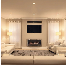 Woonkamer met wandhaard televisie en lichte zithoek in een modern interieur