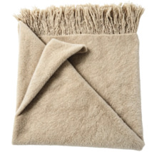 Zachte woondeken met franjes in beige.