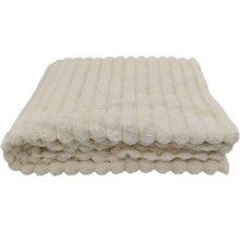 Een opgevouwen plaid van zachte pluche met een geribbelde structuur.