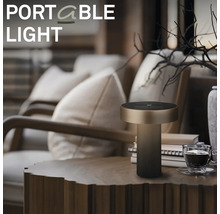 Moderne draagbare led tafellamp met cilindrische voet op een houten tafel in een gezellige woonkamer.