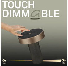 Hand raakt de bovenkant van een ronde led tafellamp met touch dimfunctie voor traploze helderheidsinstelling van tien tot honderd procent.