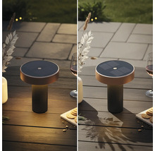 Moderne solar led tafellamp voor buiten op een houten tafel met glas en snackbord, verlicht en uitgeschakeld in vergelijking.