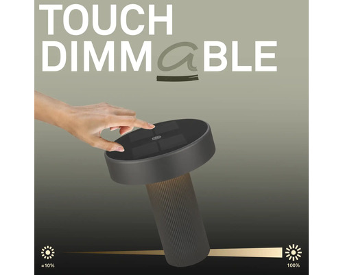 Een hand bedient de touch dimfunctie op een moderne LED tafellamp met een geribbelde voet en een platte lampkop.