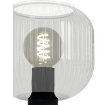 Tafellamp met geribbelde glazen behuizing en zichtbare filament lichtbron in een lamphouder.