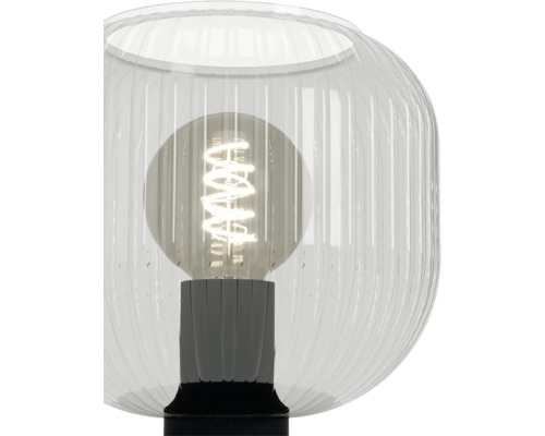 Tafellamp met geribbelde glazen behuizing en zichtbare filament lichtbron in een lamphouder.