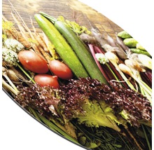 Verse groenten op een snijplank: courgette, tomaten, sla en wortelen.