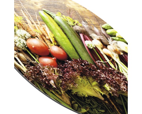 Verse groenten op een snijplank: courgette, tomaten, sla en wortelen.