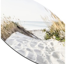 Close-up van een strand met zand, gras en zee