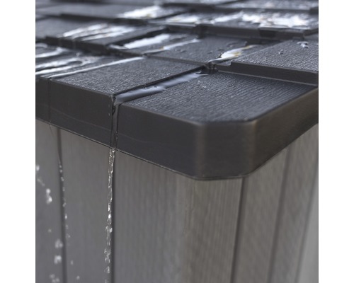 Detailopname van een tuinhuis met water dat van het dak en de muur afloopt