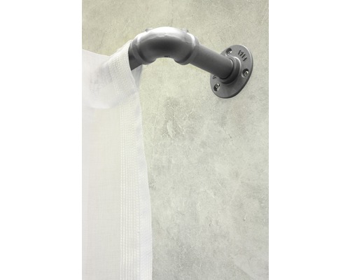 Metalen gordijnroede met witte gordijn aan een muur