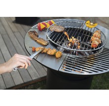Ronde barbecue met eten en barbecuetang op het grilloppervlak