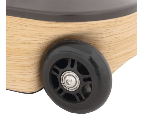 Detailopname van een speelgoedauto met een houten carrosserie en een zwart wiel