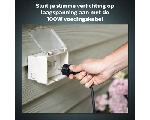 Hand steekt stekker in waterdichte contactdoos voor buiten.