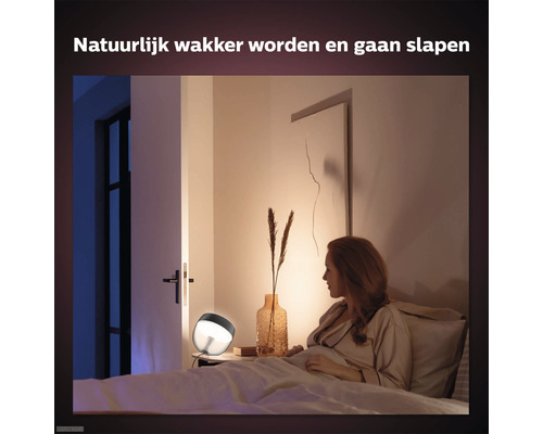 Vrouw in slaapkamer met bedlamp voor natuurlijk wakker worden