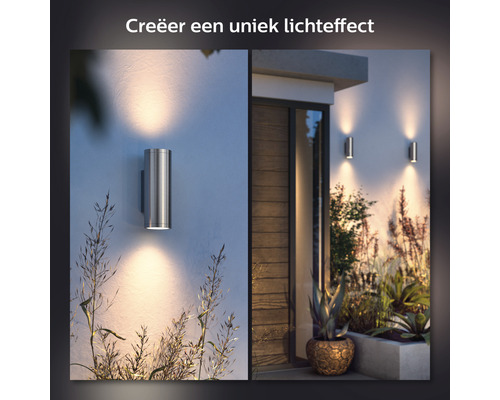 Scene met twee roestvrijstalen wandlampen aan een huismuur die een warm licht uitstralen.
