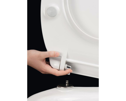 Hand monteert een toiletbril op een toilet.