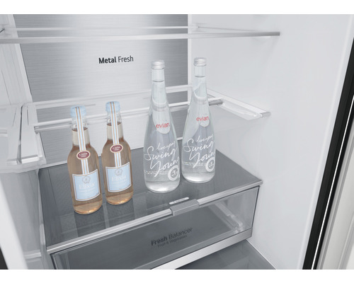 Interieur van een koelkast met glazen flessen op een plank