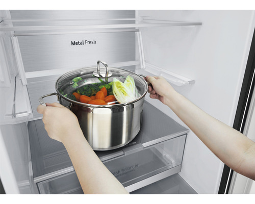 Persoon plaatst kookpan met groenten in de koelkast.