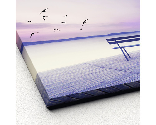Canvas schilderij met een bank aan het meer en vliegende vogels