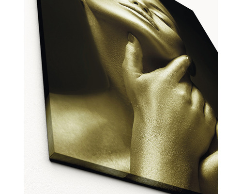 Close-up van een goudkleurige kunstdruk waarop een vrouw staat afgebeeld die met haar hand haar gezicht aanraakt