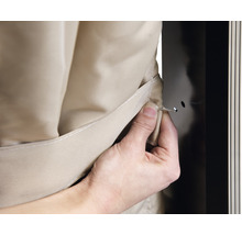 Bevestiging van een beige textielbekleding aan een kast met een pin