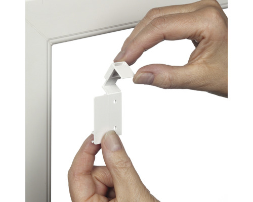 Persoon monteert een lamelhouder op een raamkozijn