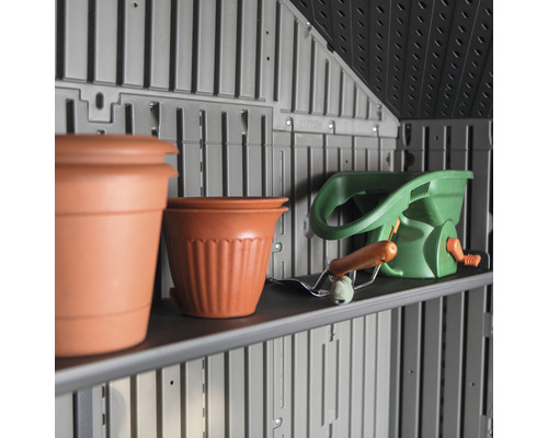 Plank in tuinhuis met bloempotten en strooiwagen