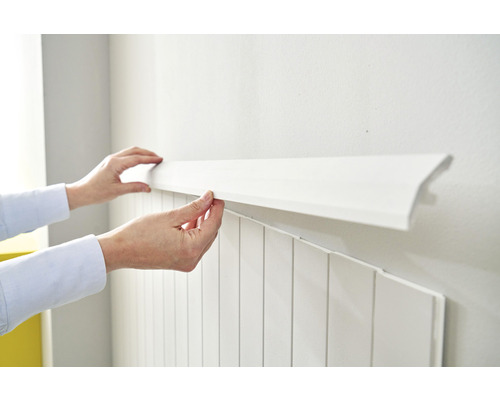 Persoon bevestigt witte wandpanelen aan de muur